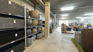 Innenansicht Permapack Lagerverkauf mit gartec Fiberstone Gefässen in Regalen sowie weiteren ausgestellten Pflanzengefässen